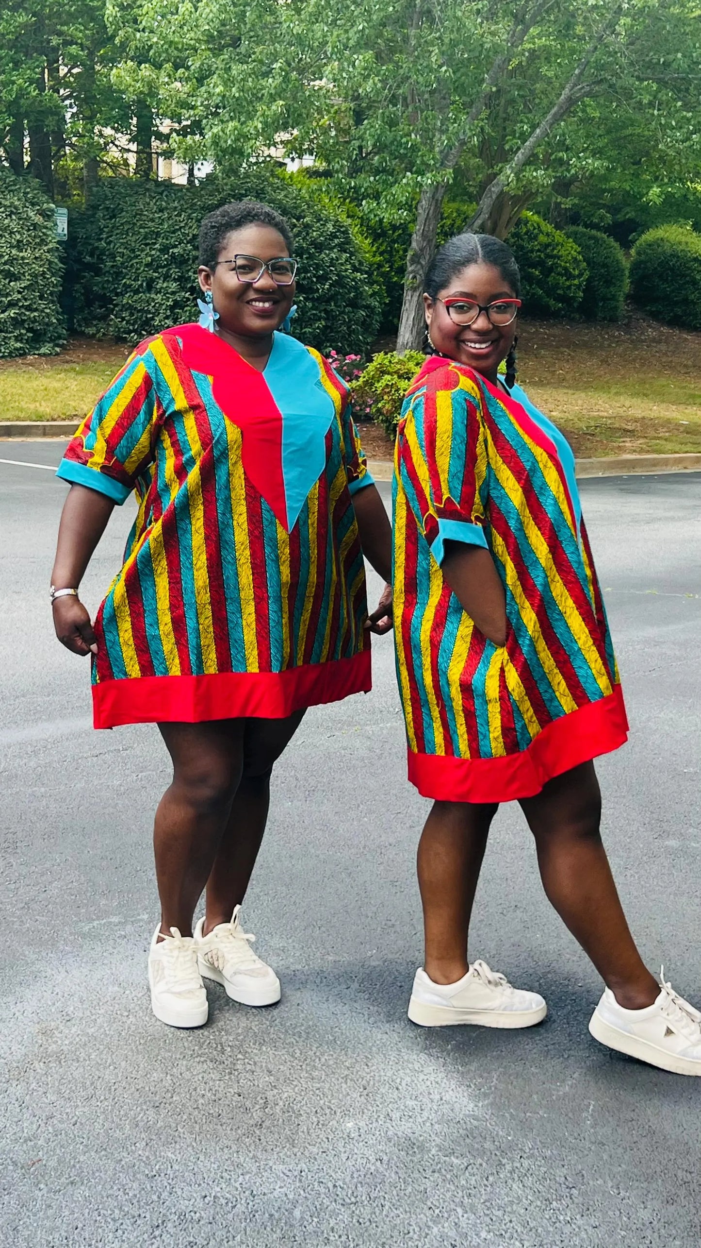 Woman wearing a vibrant African Ankara print mini dress with short sleeves and a flattering A-line silhouette, standing outdoors.