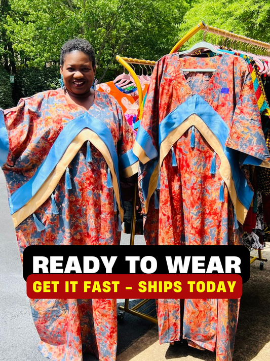 Woman wearing a floor-length Adire and Kampala print dress with angular crepe accents and tassel details, standing outdoors.