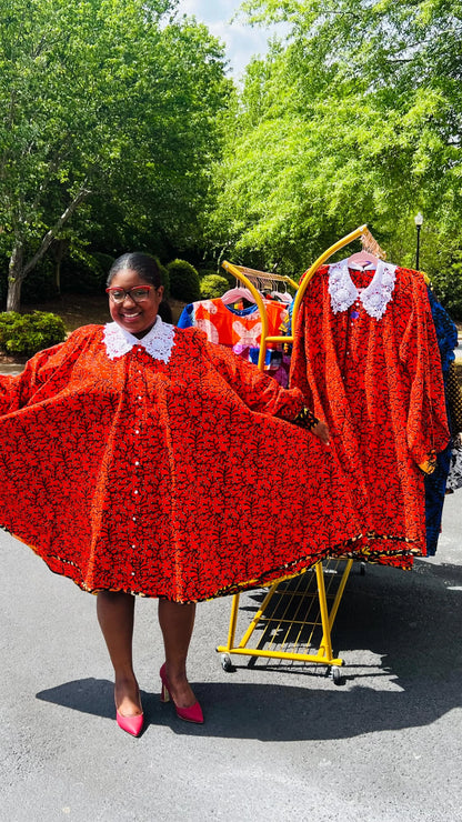 Woman wearing a vibrant Ankara full-circle A-line dress with a lace collar, standing outdoors.