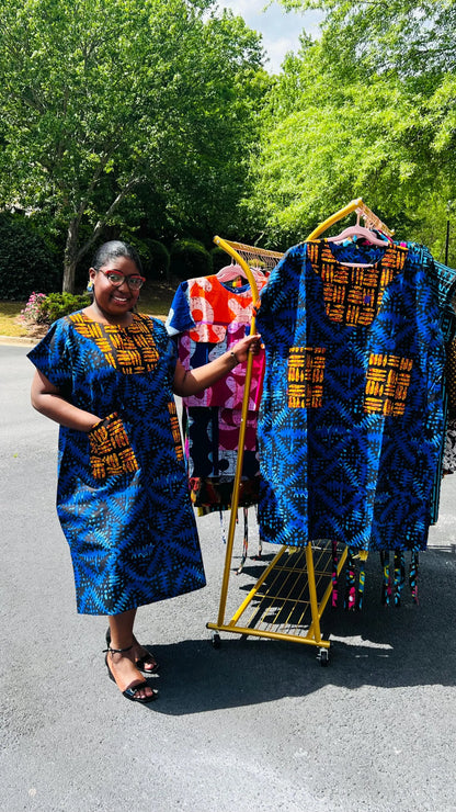 Woman wearing a floor-length Ankara Bubu gown with wide sleeves, front pockets, and a relaxed fit, standing outdoors.