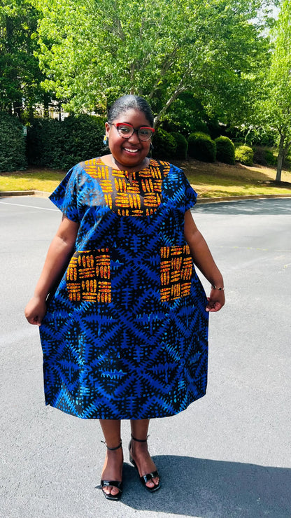 Woman wearing a floor-length Ankara Bubu gown with wide sleeves, front pockets, and a relaxed fit, standing outdoors.