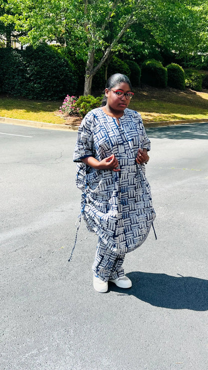 Woman wearing a two-piece African print Adire set with a drawstring Bubu top and matching baggy pants, standing outdoors.