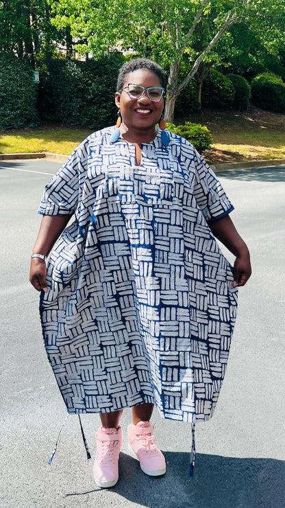 Woman wearing a two-piece African print Adire set with a drawstring Bubu top and matching baggy pants, standing outdoors.