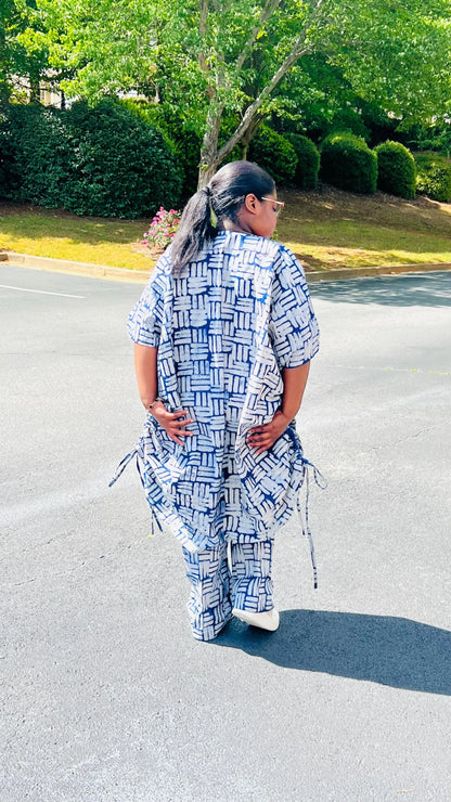 Woman wearing a two-piece African print Adire set with a drawstring Bubu top and matching baggy pants, standing outdoors.