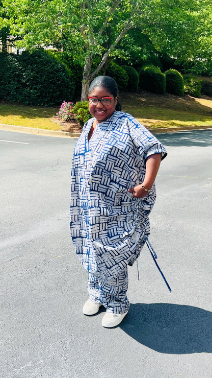 Woman wearing a two-piece African print Adire set with a drawstring Bubu top and matching baggy pants, standing outdoors.