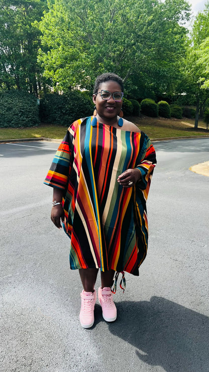 Woman wearing a two-piece African print set featuring an off-shoulder drawstring Bubu top and matching wide-leg pants, standing outdoors.