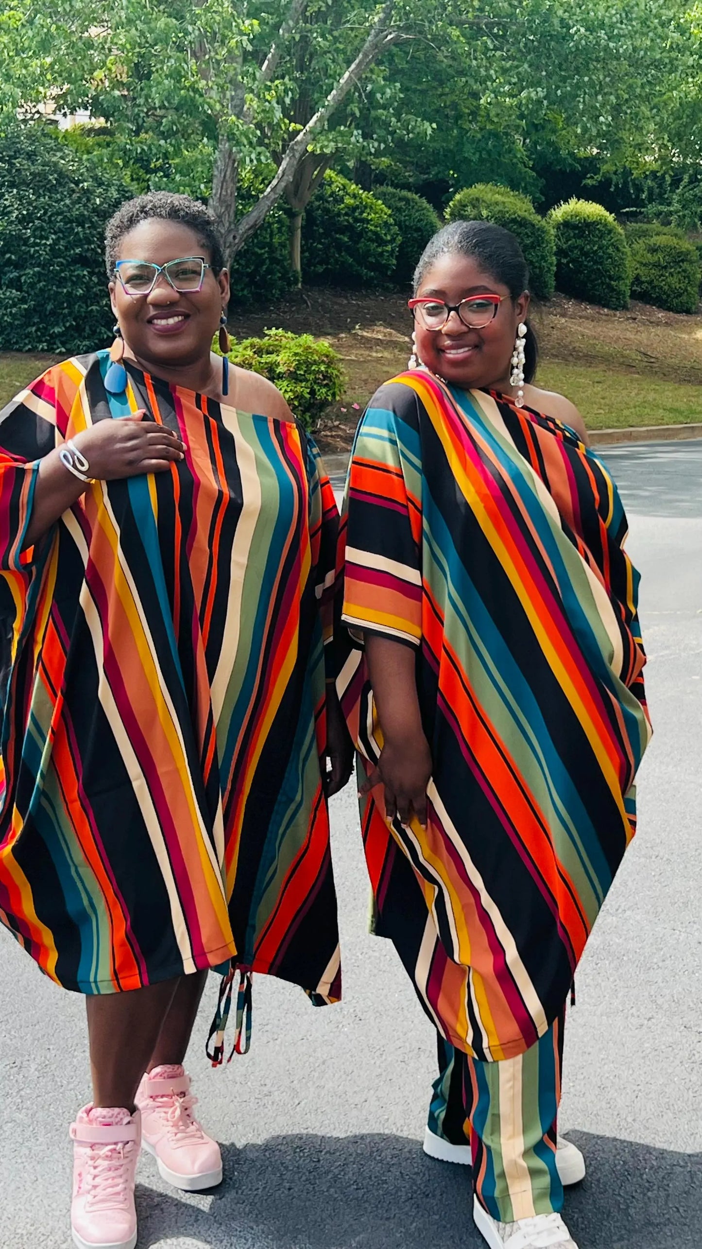 Woman wearing a two-piece African print set featuring an off-shoulder drawstring Bubu top and matching wide-leg pants, standing outdoors.
