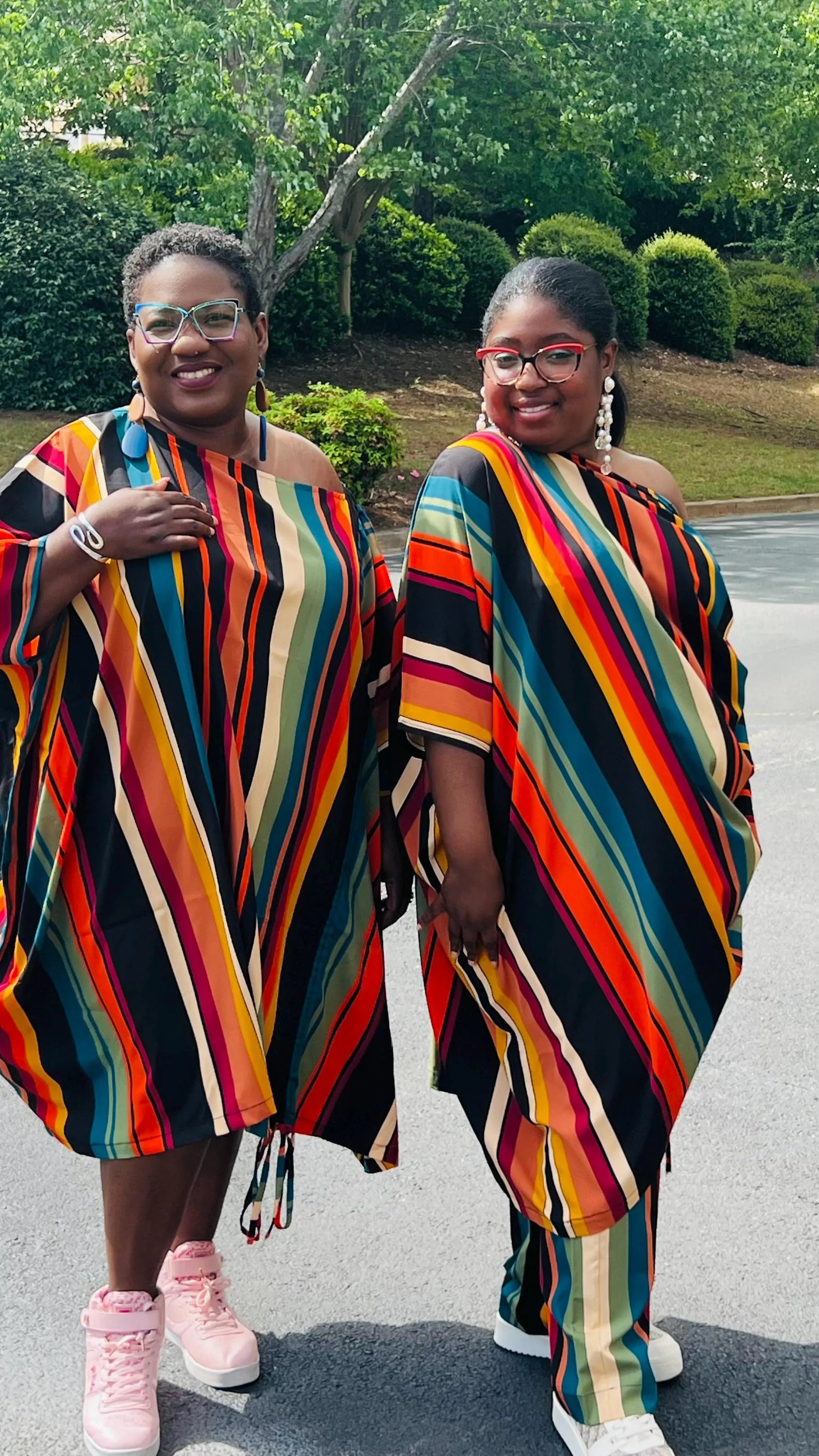 Woman wearing a two-piece African print set featuring an off-shoulder drawstring Bubu top and matching wide-leg pants, standing outdoors.