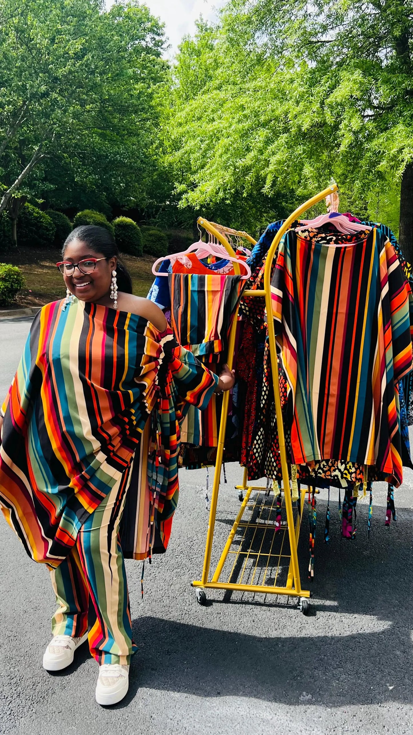 Woman wearing a two-piece African print set featuring an off-shoulder drawstring Bubu top and matching wide-leg pants, standing outdoors.
