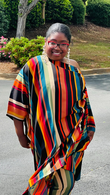 Woman wearing a two-piece African print set featuring an off-shoulder drawstring Bubu top and matching wide-leg pants, standing outdoors.