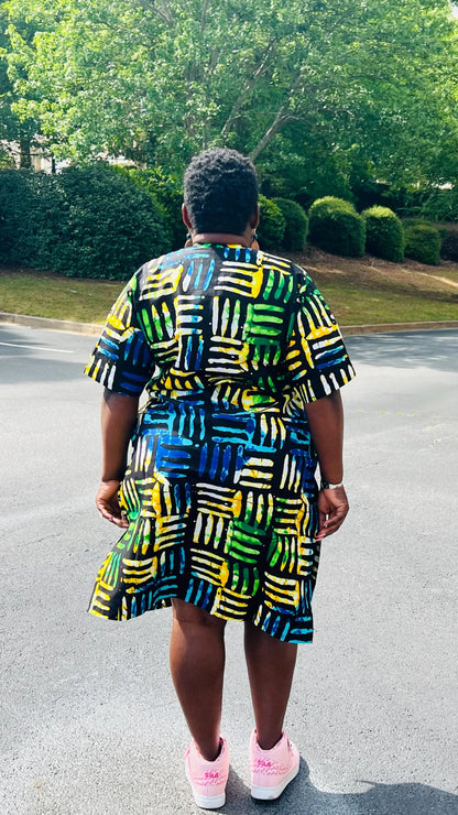 Woman wearing a two-piece Ankara outfit featuring a button-up top and matching baggy pants with an elastic waistband, standing outdoors.