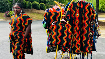 Woman wearing a three-piece Ankara ensemble featuring a fitted top, wide-leg pants, and a flowing kimono-style jacket, standing outdoors.