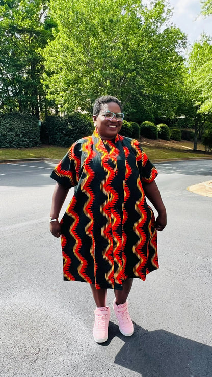 Woman wearing a three-piece Ankara ensemble featuring a fitted top, wide-leg pants, and a flowing kimono-style jacket, standing outdoors.