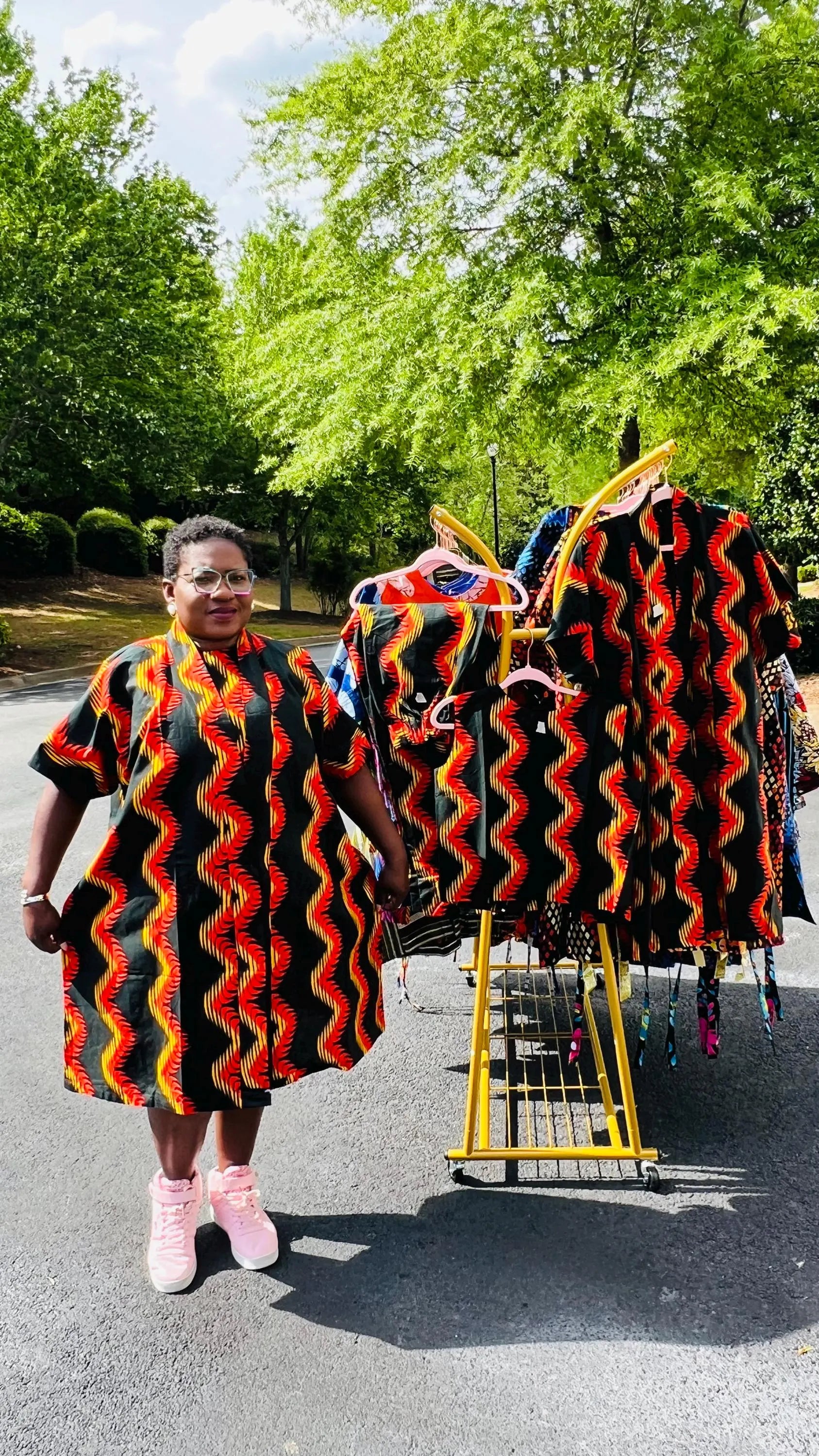 Woman wearing a three-piece Ankara ensemble featuring a fitted top, wide-leg pants, and a flowing kimono-style jacket, standing outdoors.