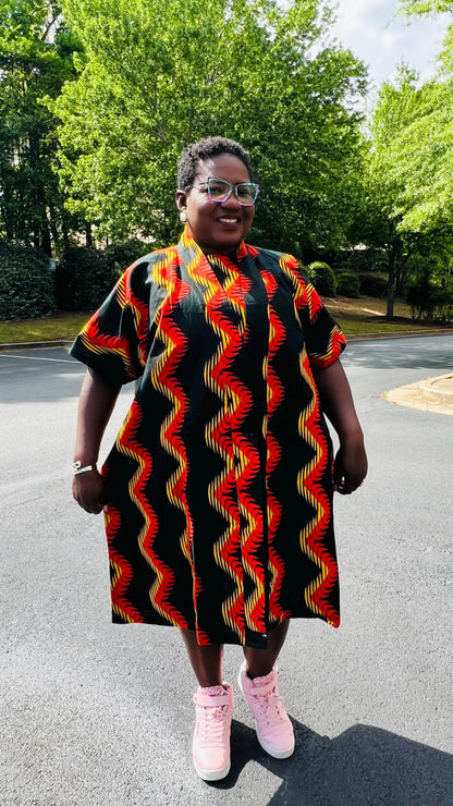 Woman wearing a three-piece Ankara ensemble featuring a fitted top, wide-leg pants, and a flowing kimono-style jacket, standing outdoors.