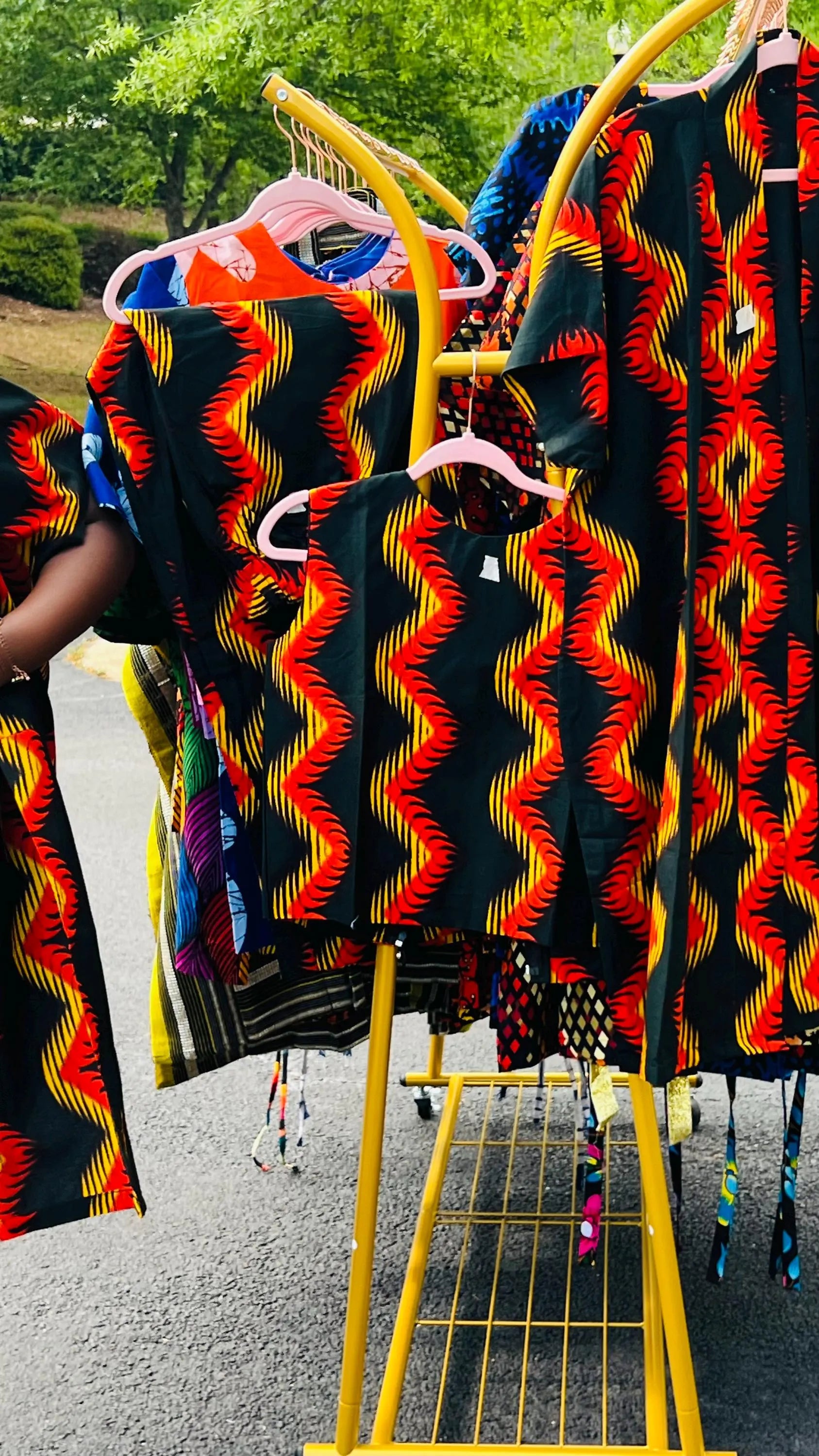 Woman wearing a three-piece Ankara ensemble featuring a fitted top, wide-leg pants, and a flowing kimono-style jacket, standing outdoors.