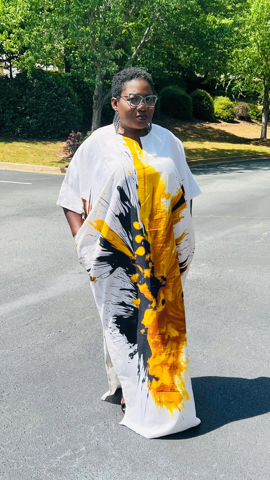 Woman wearing a vibrant, floor-length African print Bubu dress with wide sleeves and a relaxed fit, standing outdoors.