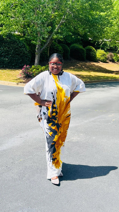Woman wearing a vibrant, floor-length African print Bubu dress with wide sleeves and a relaxed fit, standing outdoors.