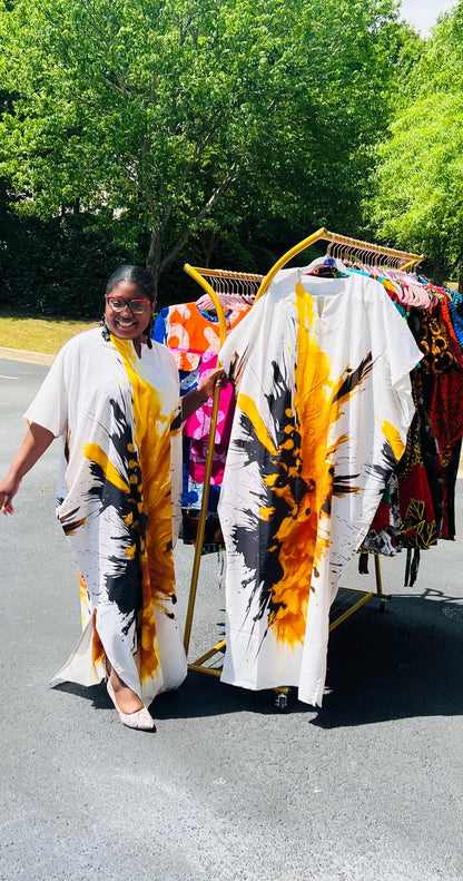 Woman wearing a vibrant, floor-length African print Bubu dress with wide sleeves and a relaxed fit, standing outdoors.