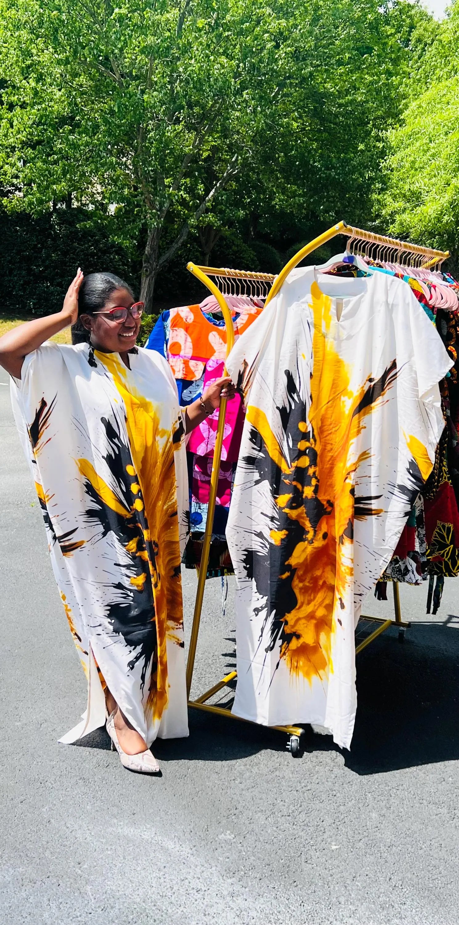 Woman wearing a vibrant, floor-length African print Bubu dress with wide sleeves and a relaxed fit, standing outdoors.