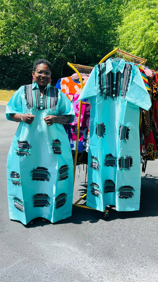 Woman wearing a floor-length Aso Oke dress with vibrant African prints, featuring a fitted bodice and flared skirt, posing outdoors.