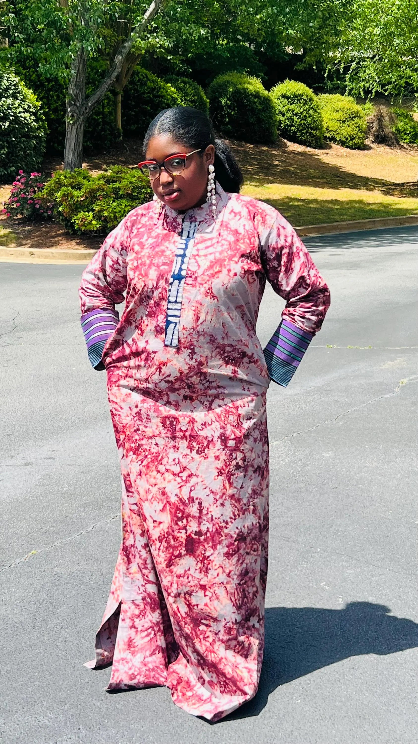 Woman wearing a boho-style maxi dress featuring vibrant Kampala Adire print and Aso Oke accents, with a relaxed fit and wide sleeves.
