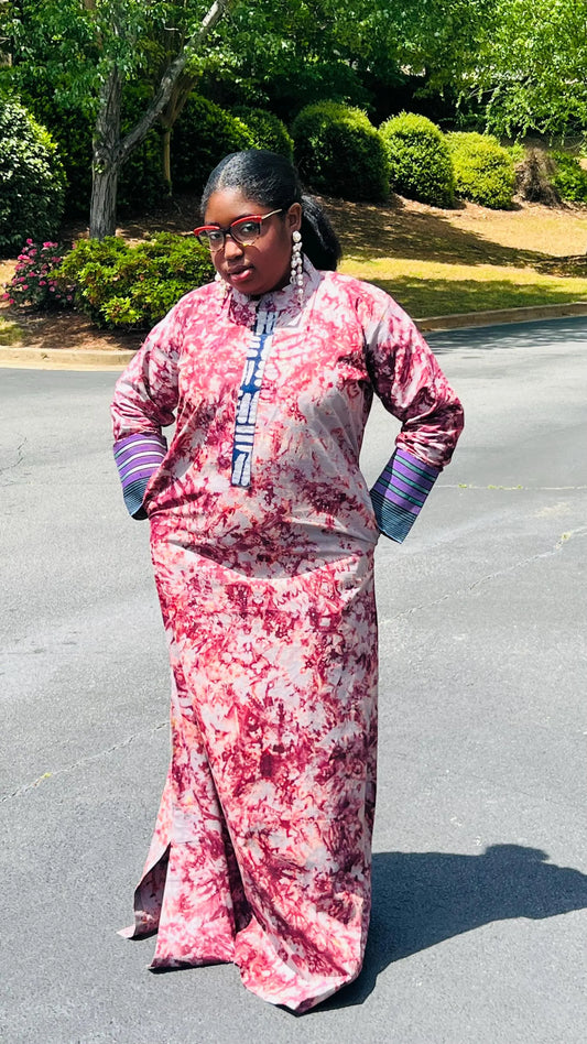 Woman wearing a boho-style maxi dress featuring vibrant Kampala Adire print and Aso Oke accents, with a relaxed fit and wide sleeves.
