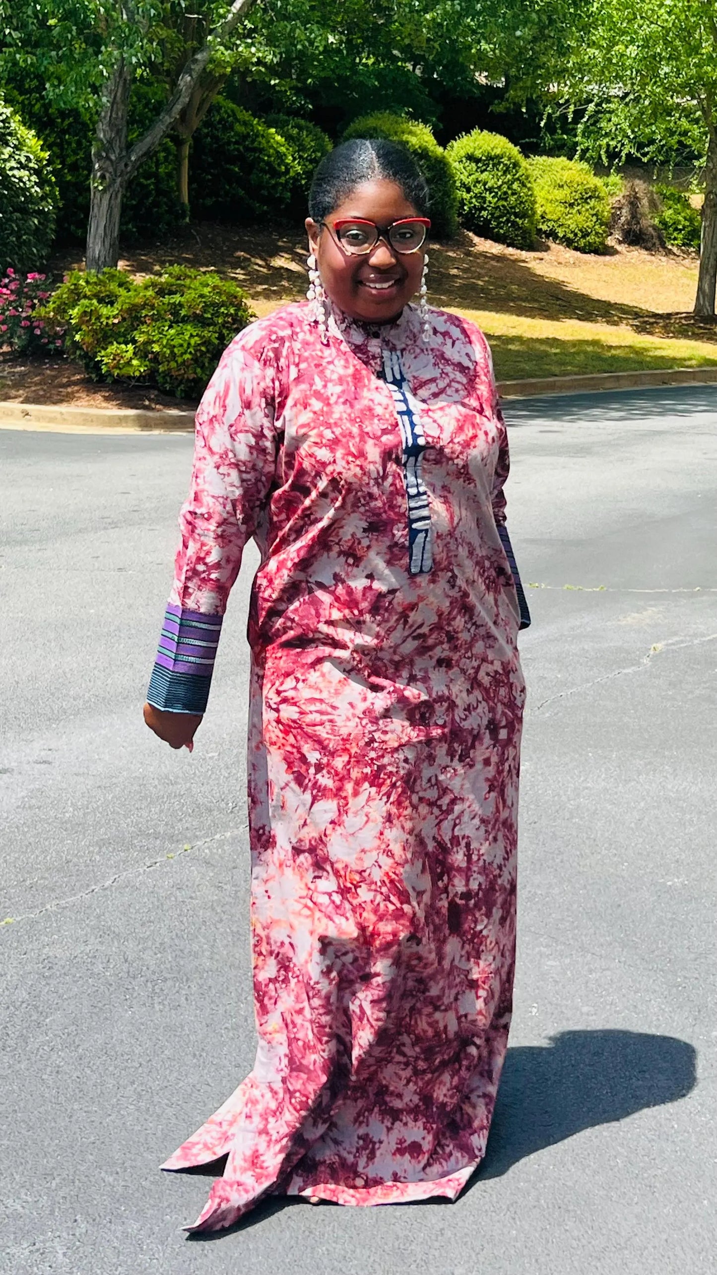 Woman wearing a boho-style maxi dress featuring vibrant Kampala Adire print and Aso Oke accents, with a relaxed fit and wide sleeves.