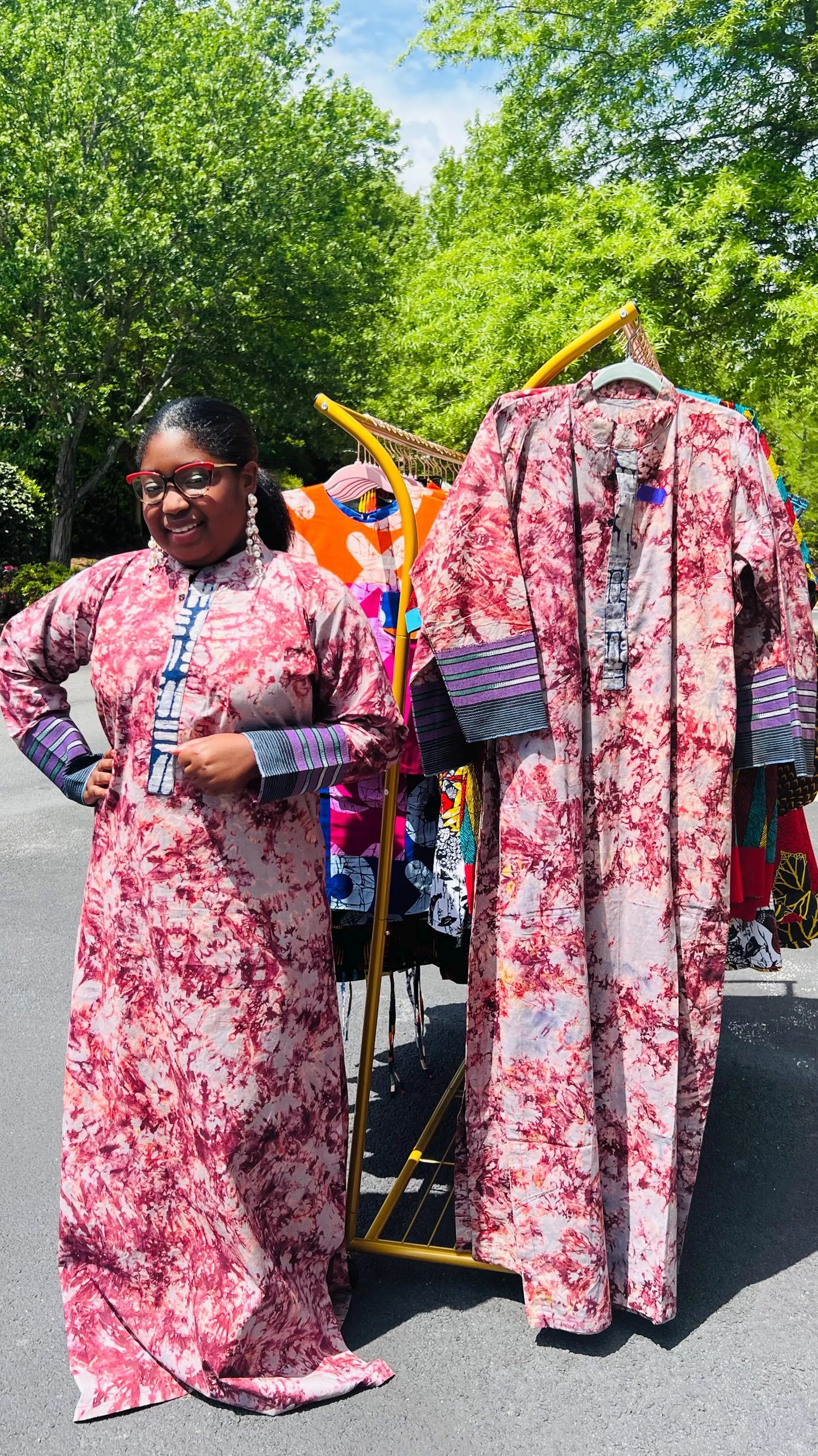Woman wearing a boho-style maxi dress featuring vibrant Kampala Adire print and Aso Oke accents, with a relaxed fit and wide sleeves.