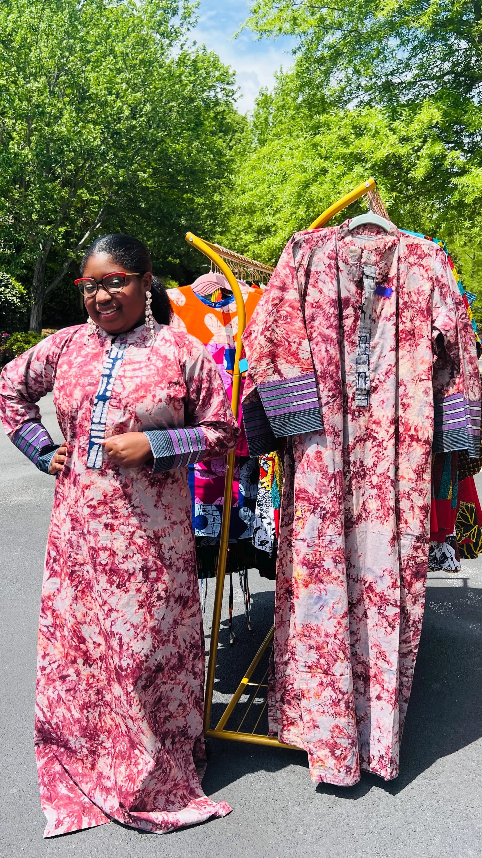 Woman wearing a boho-style maxi dress featuring vibrant Kampala Adire print and Aso Oke accents, with a relaxed fit and wide sleeves.