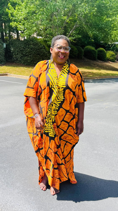 Woman wearing a vibrant, floor-length Ankara Bubu gown with wide sleeves and a relaxed fit, standing outdoors.